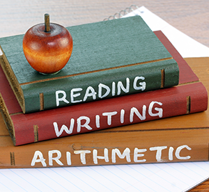 Books on a table saying reading, writing, and arithmetic